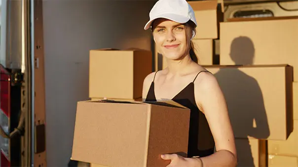 Femme avec une casquette qui tient un carton